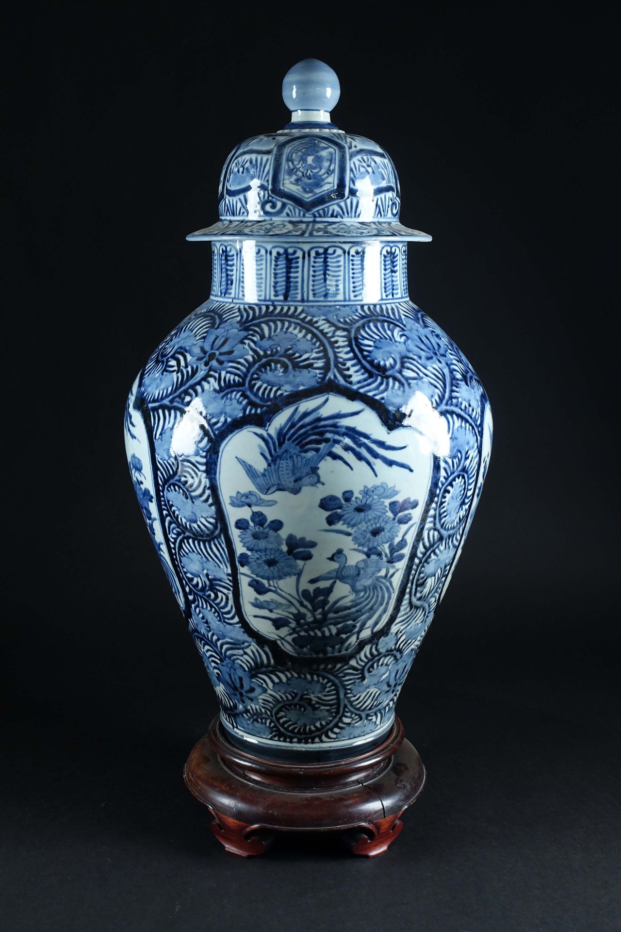 Arita. 一个非常大的有盖花瓶，上面有小鸟在花丛中飞翔的图案，从一个装饰着叶子的背景中脱颖而出。蓝/白珐琅彩瓷器。日本。江户时期。17世纪。高度：77厘米。&hellip;
