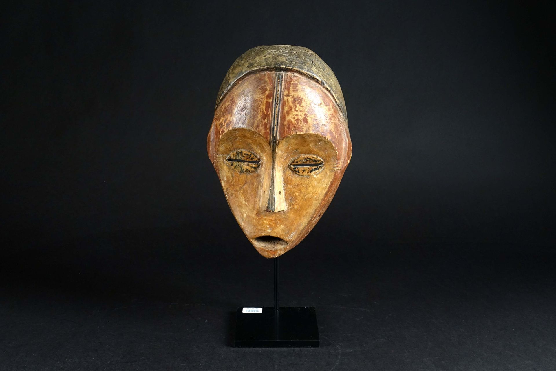 Masque Ngbaka. 有一张凹陷的脸和半闭的咖啡豆眼睛，由一个锥形的鼻子分开，鼻梁延伸到额头上。雕刻的木头上有铜锈和彩色颜料的痕迹。刚果民主共和国。高度&hellip;