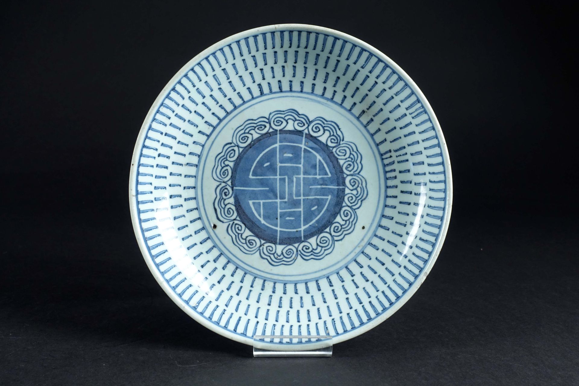 CHINE. 外销瓷圆盘，白色/蓝色珐琅彩，中间是长寿的 "寿 "字，边上是长生的蘑菇楣。19世纪初。直径：27厘米。状态：一根头发（约4厘米）。