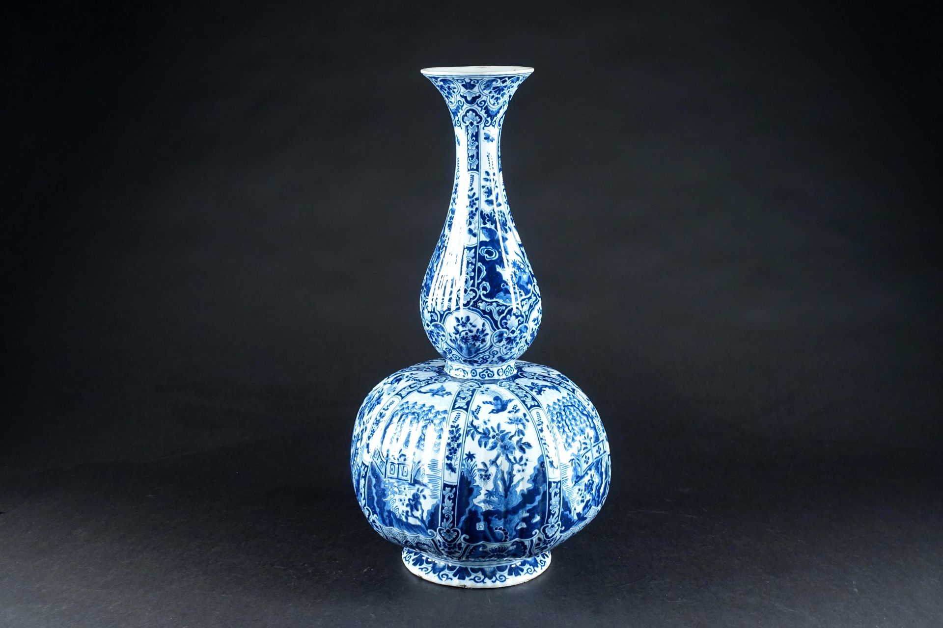 Delft. 大瓶花瓶，有郁金香型的颈部和直棱。釉面陶器，蓝色单色和备用，具有中国风格的宫廷和开花植物的装饰。马克。高度：63厘米。状态：无事故或修复。一些珐琅&hellip;