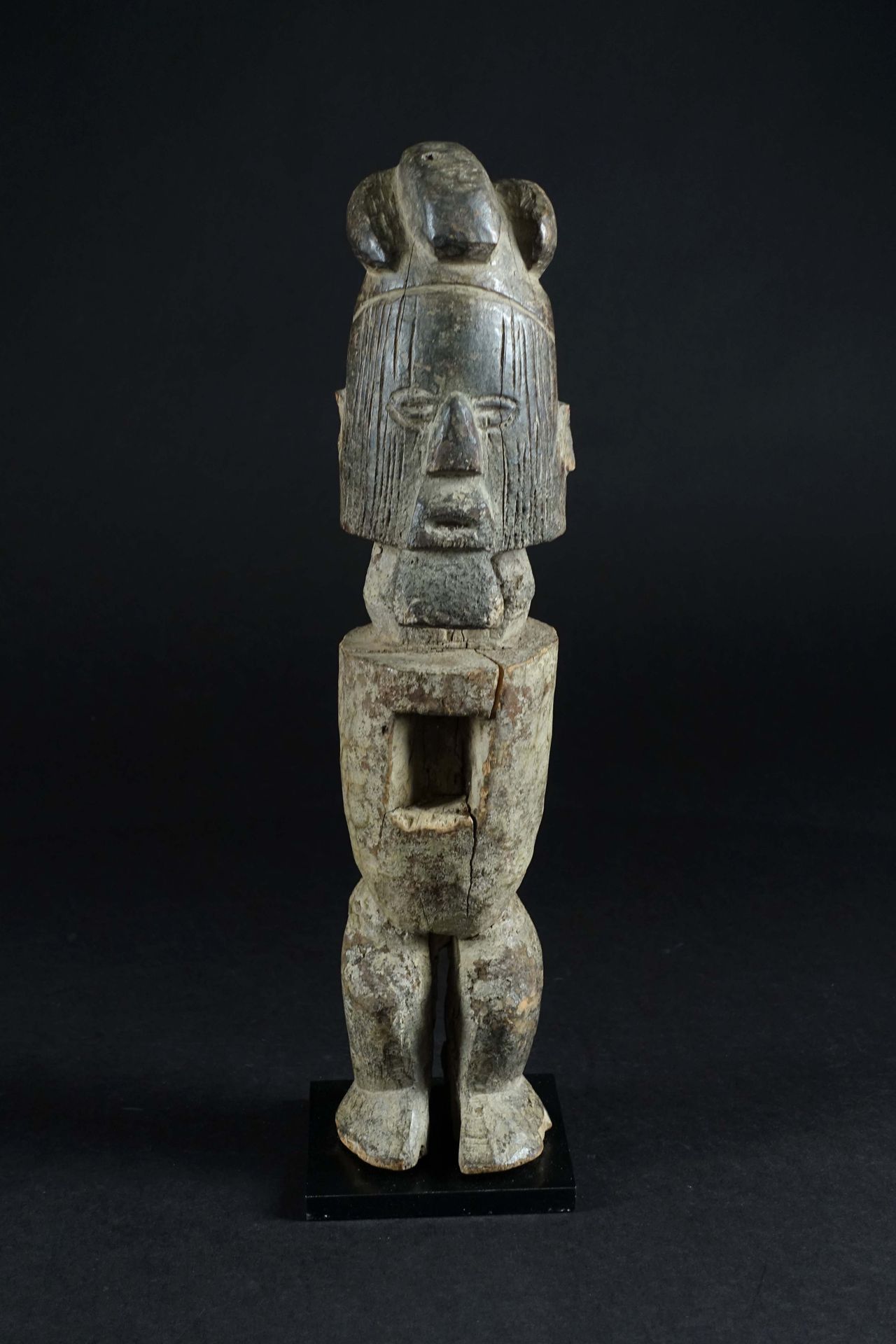 Reliquaire Téké. 描绘的是一个没有手臂的站立人物，有图表化的特征，腹部被一个空洞掏空了。雕花木料，有古色古香。刚果民主共和国。高度：38厘米。