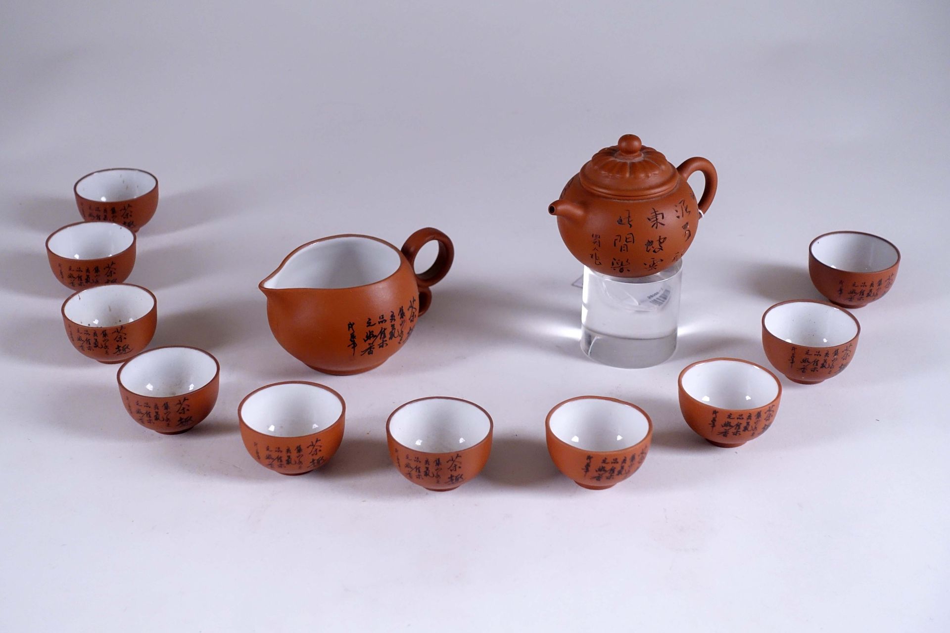 Yixing. 小茶壶，红泥，刻有竹子装饰。标记（长度：11厘米）。附有十个小杯（直径：5厘米）和一个水壶。中国。20世纪。