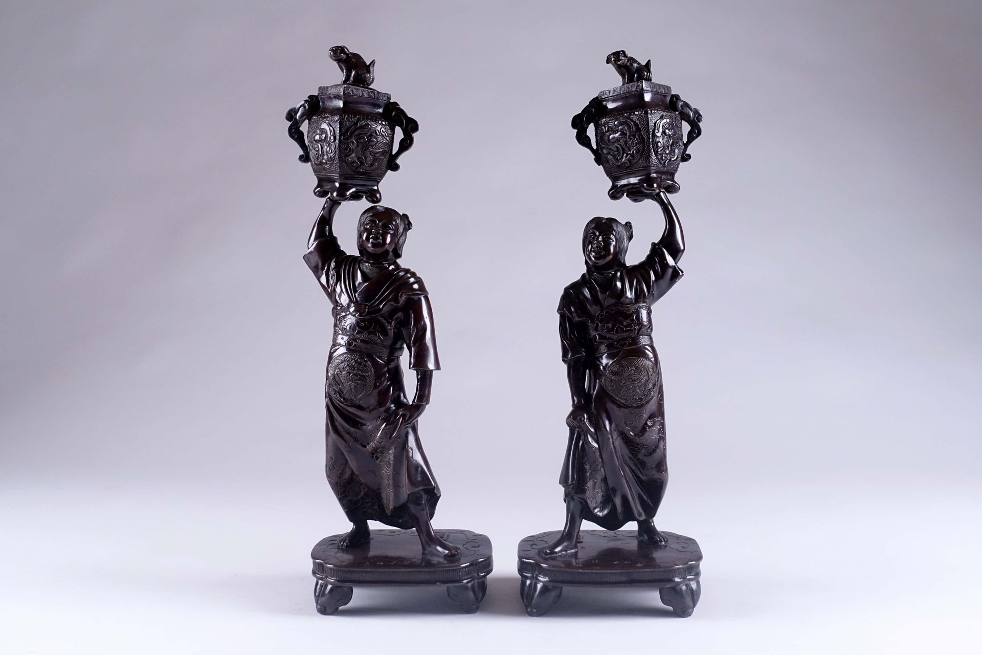 JAPON. 一对烛台，每个烛台都有一个站立的人物，拿着一个有活动盖子的Koro花瓶，形成一个Binet。青铜器。明治时期的作品。在露台上签名。高度：41厘米。