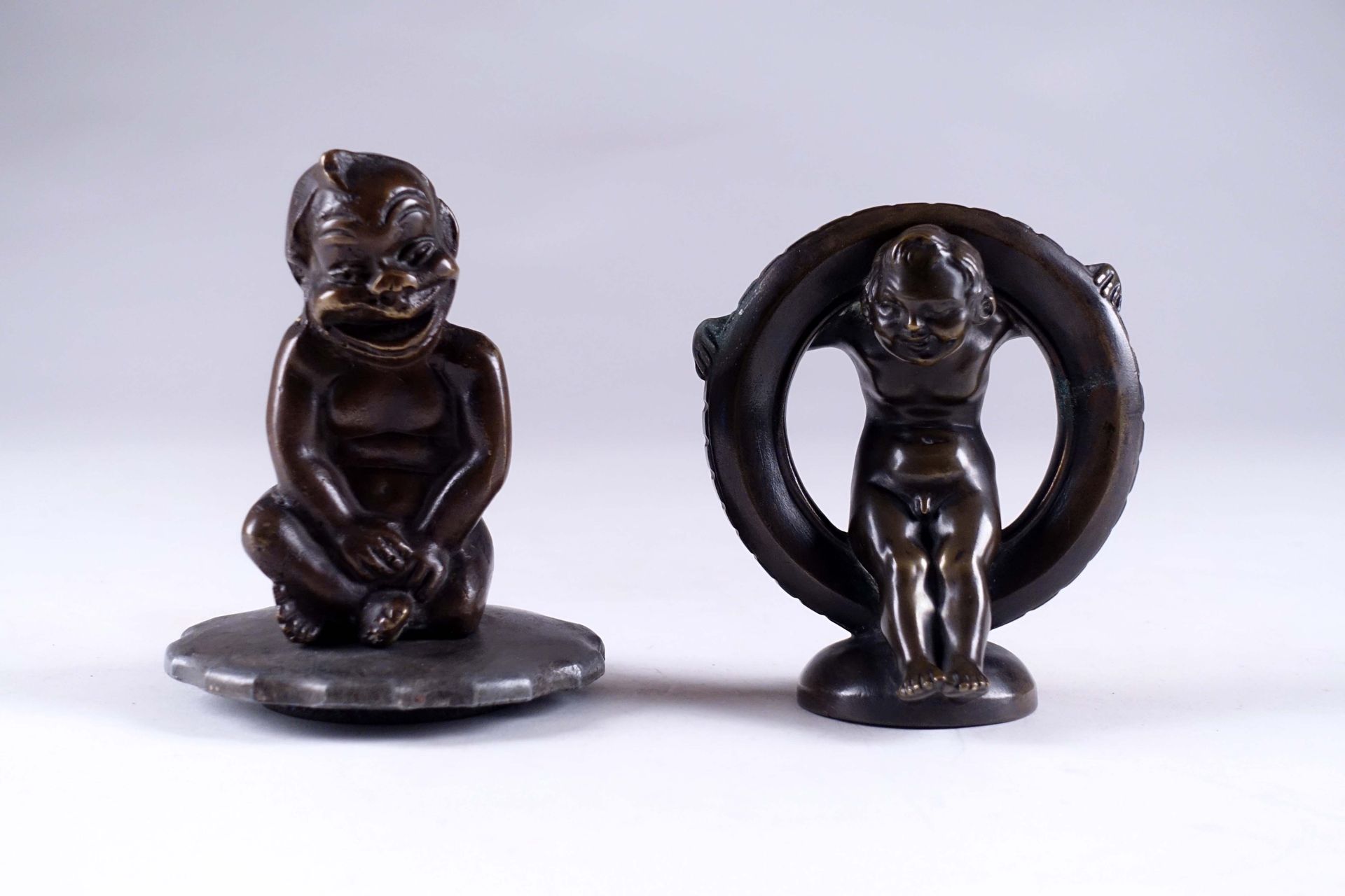 Biliken (fétiche porte-bonheur) et enfant assis dans un pneu. 两个铜质吉祥物。法国1920-192&hellip;