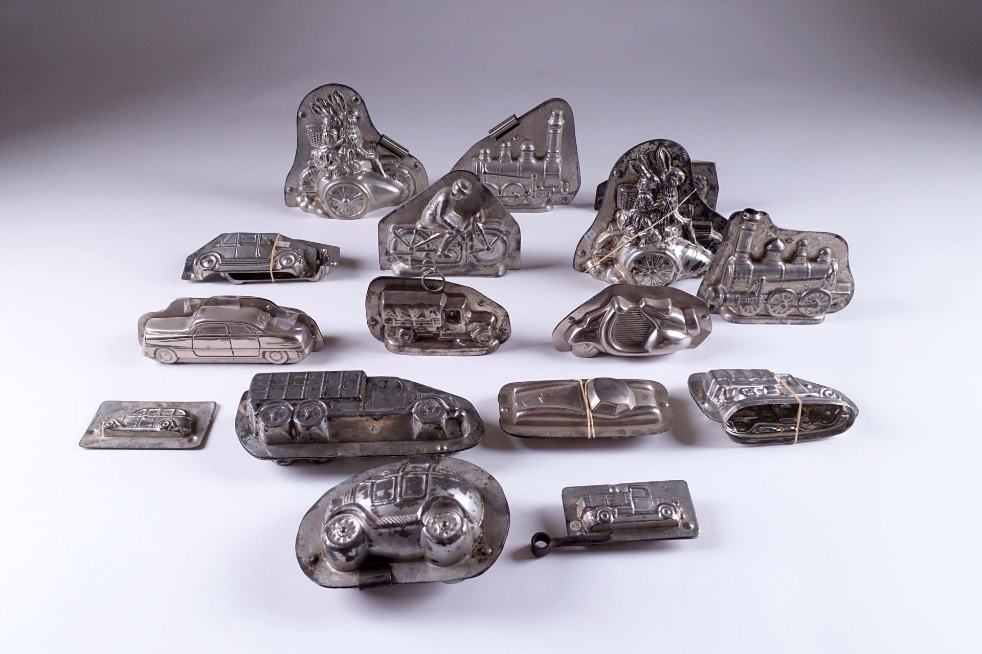 Collection de seize anciens moules à chocolat. 描绘了汽车、侧车、卡车和机车。金属。高度：5至15厘米。
