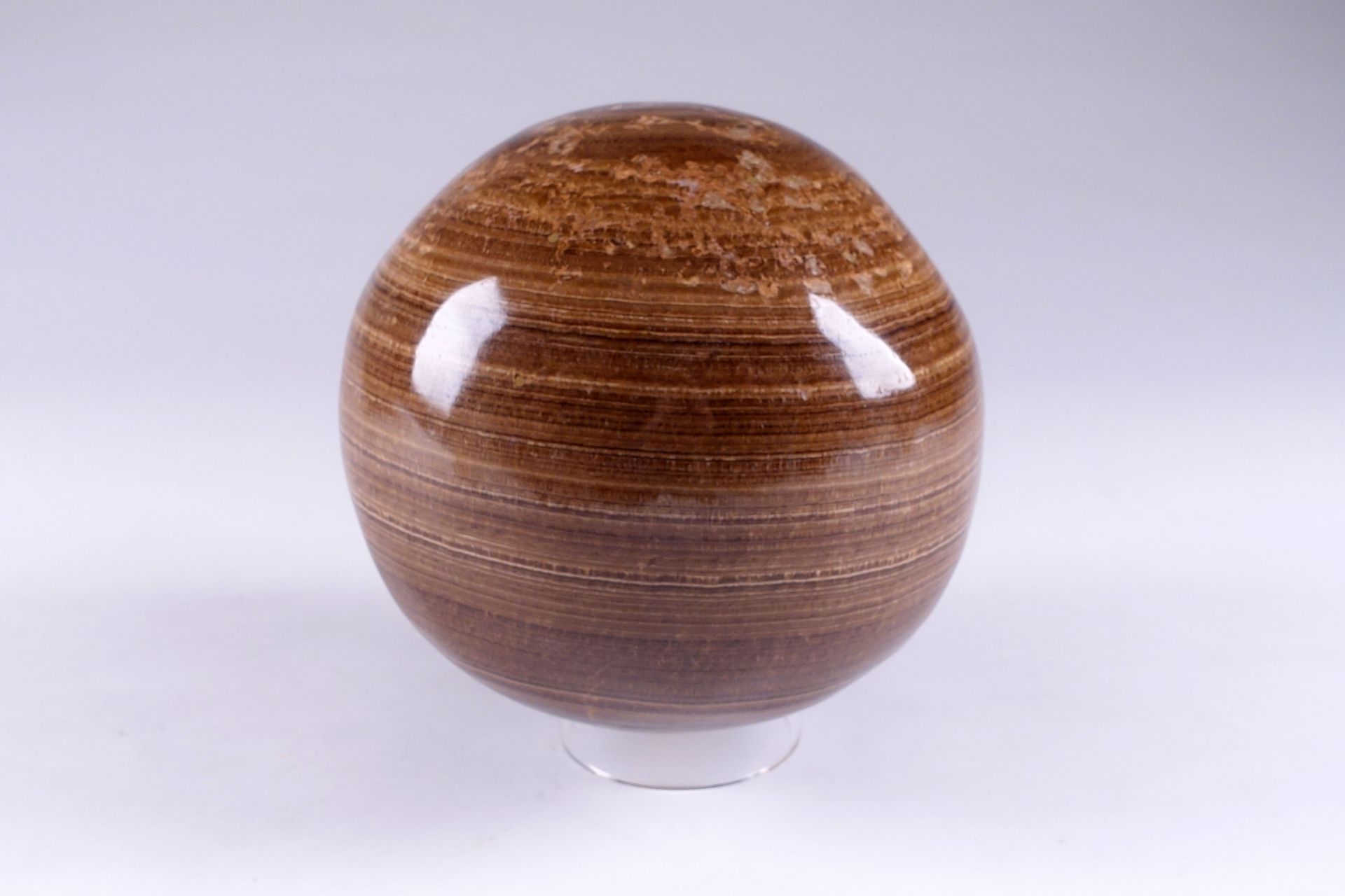 Sphère. Aragonite brune rubanée polie. Diamètre : environ 15 cm.