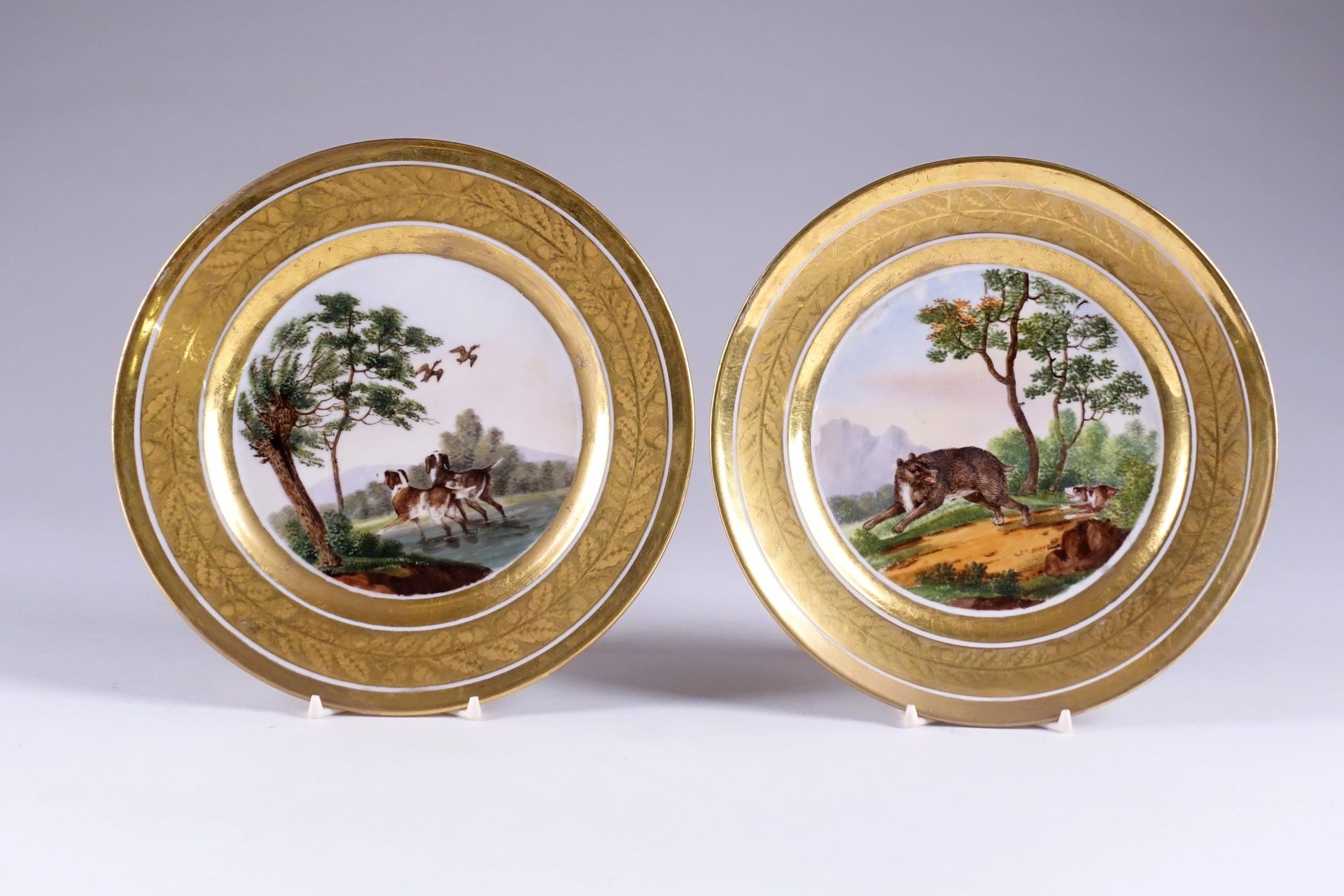 Schoelcher. 一对多色画的盘子，上面有狗和猎物的狩猎场景。翼上有两个金饰，饰有橡树叶和橡子的双楣。巴黎的瓷器。19世纪的前三分之一。狀況報告：無事故，&hellip;