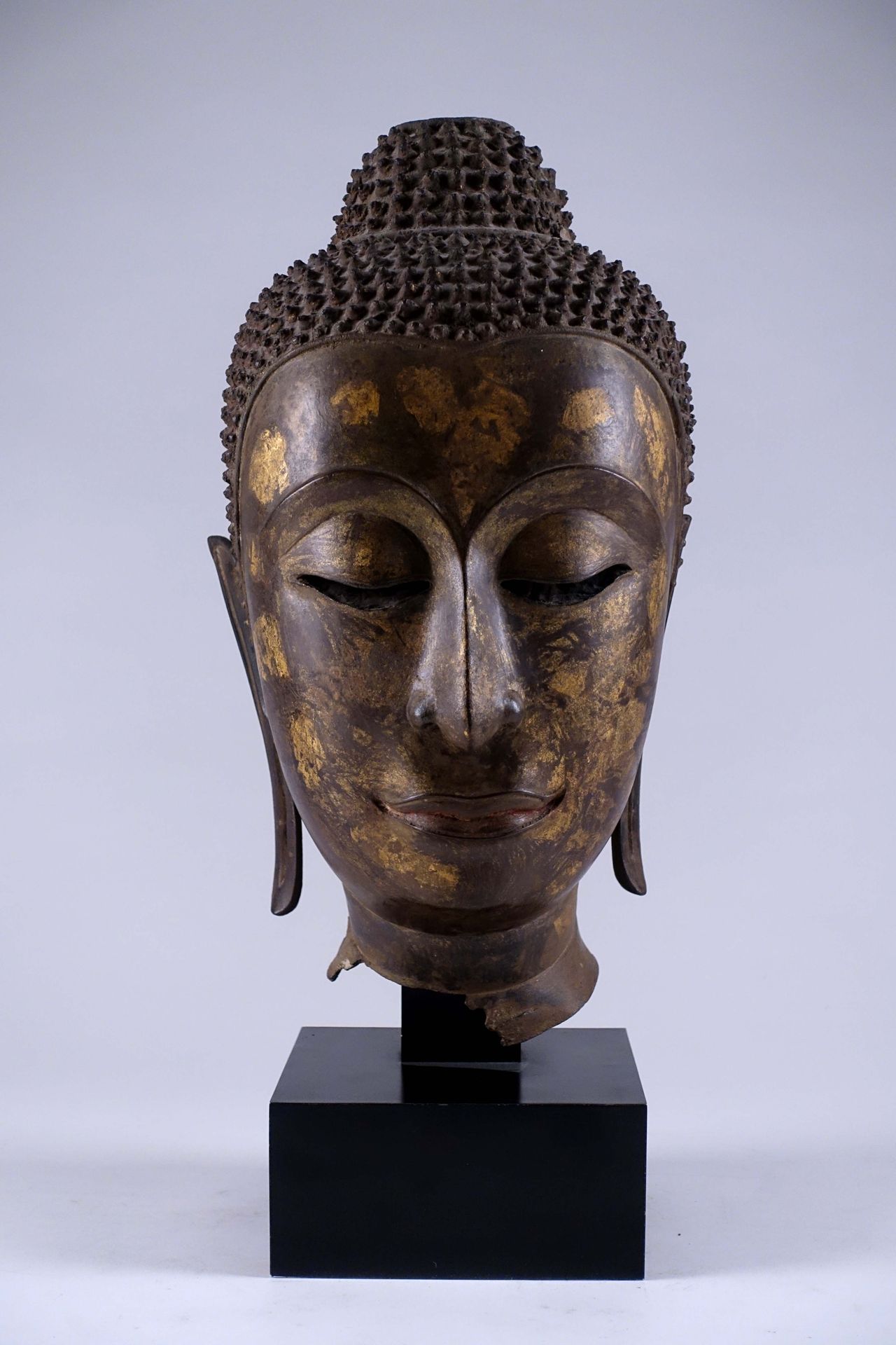 Importante tête de Bouddha Shakyamuni. A l’expression sereine, esquissant un sou&hellip;