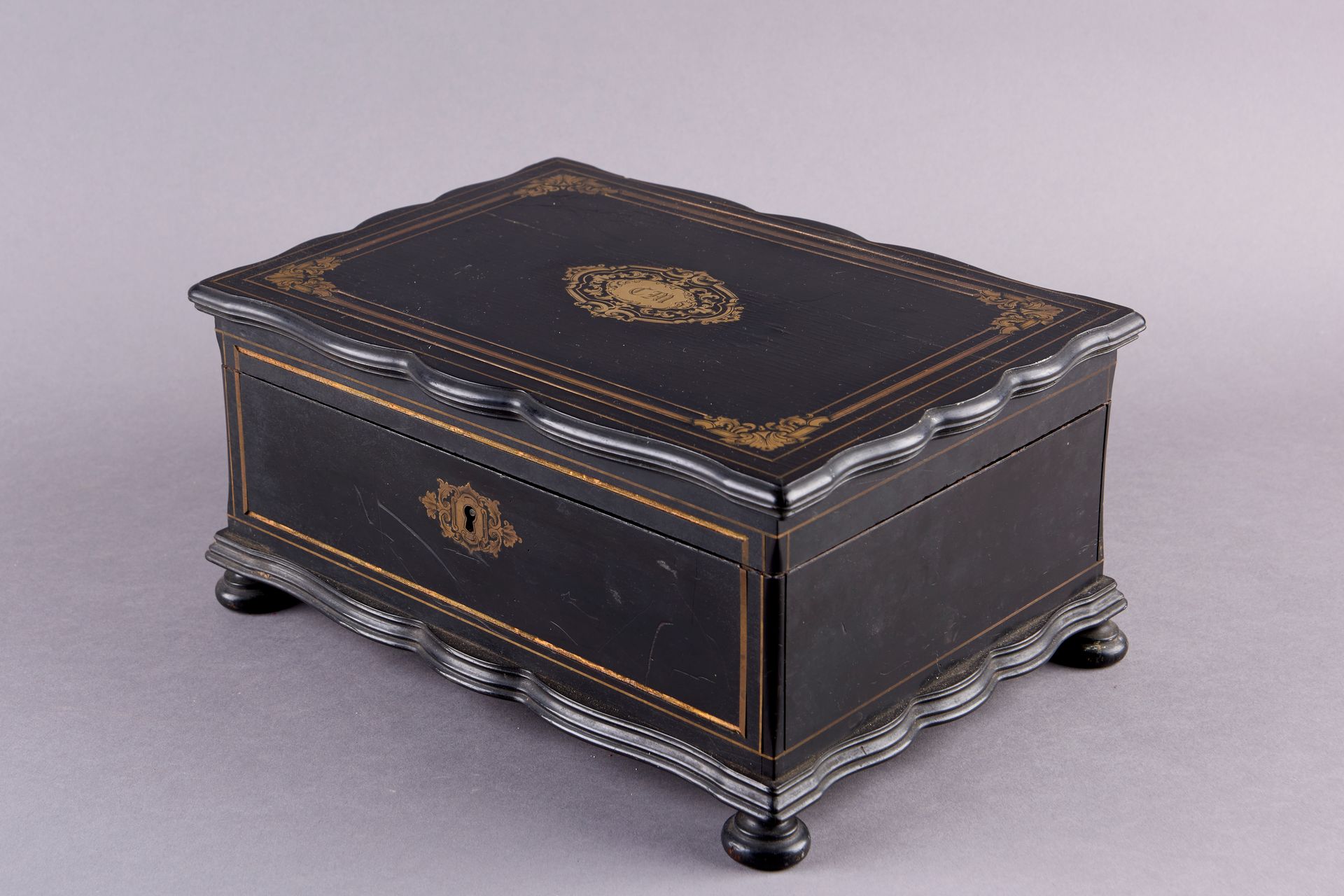 Null 熏黑的木头和黄铜镶嵌盒，上面有一个带有字母图案的卡口，丝带和网。拿破仑三世时期。14 x 29 x 20厘米。(事故)