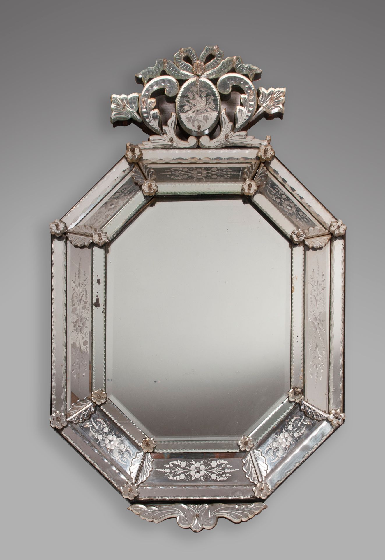 Null 大的长方形威尼斯镜子，有切边和玻璃花，顶部是一个装饰有鸽子的花环，花环由一个绳结固定。尺寸为124 x 73厘米。(事故)