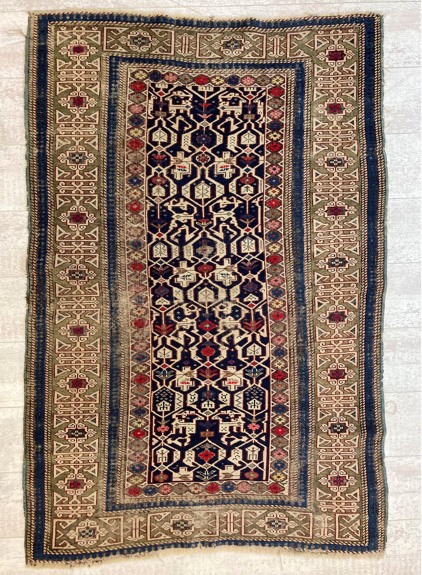 Null 哈萨克羊毛地毯，米色背景上有风格化的花卉装饰，绿色背景上有缠结图案的宽边。160 x 105厘米。(穿着)