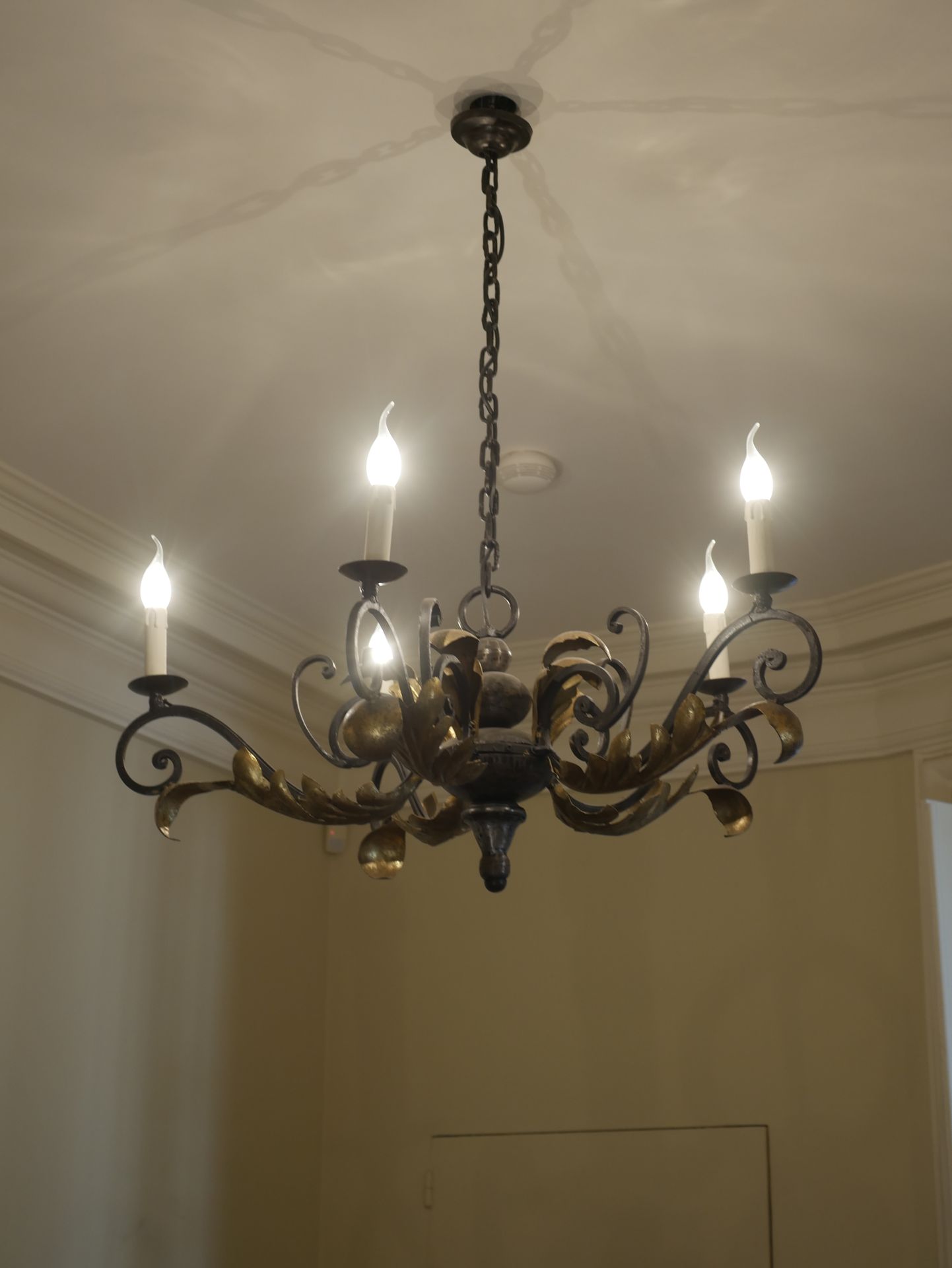 Null Un lampadario in ferro battuto dorato con cinque bracci di luce decorati co&hellip;