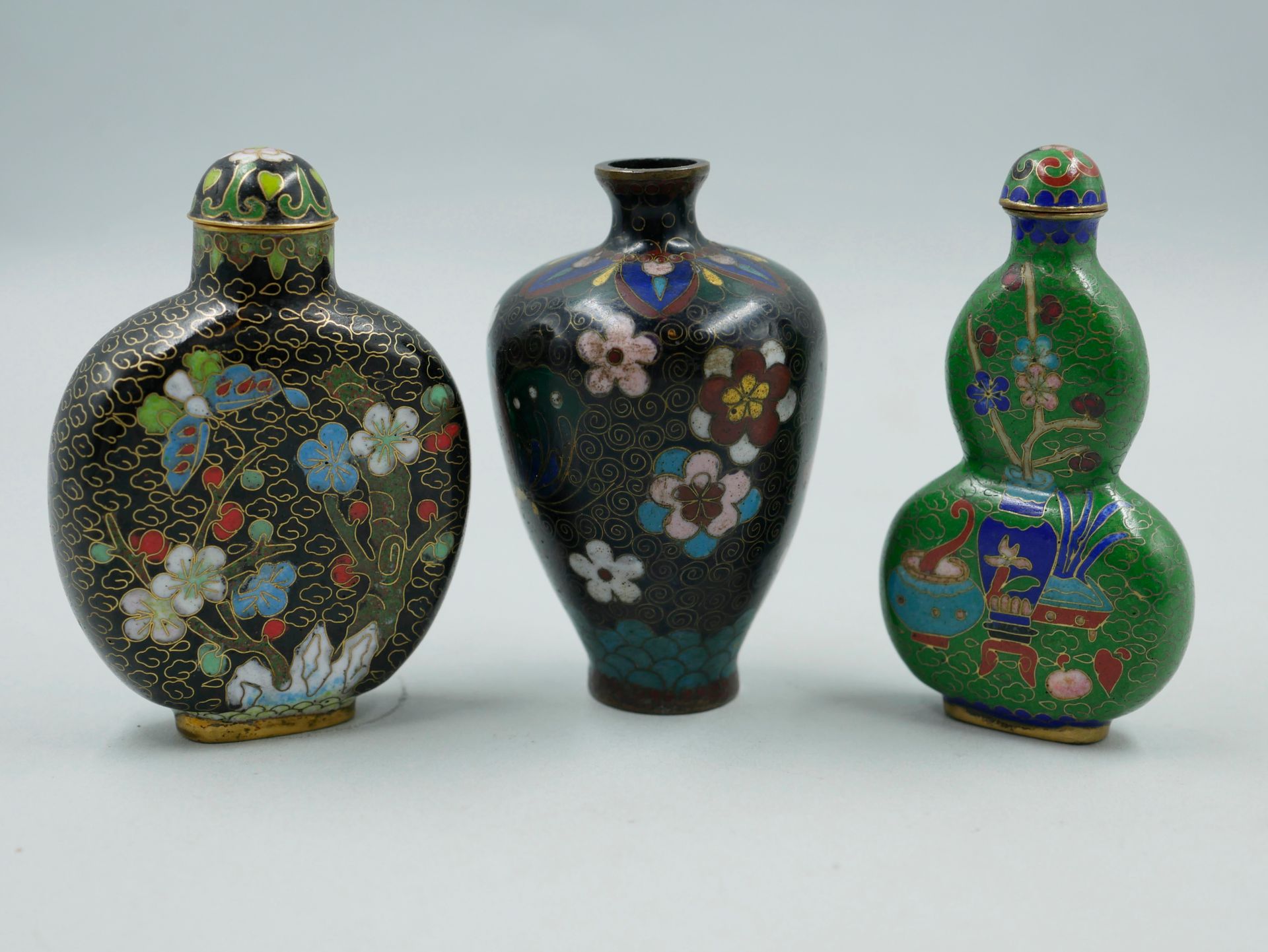 Null 中国。两个掐丝铜和多色珐琅的鼻烟壶，装饰着梅花枝和花瓶。高8厘米。一件景泰蓝青铜和多色珐琅的小花瓶，黑底有蝴蝶和花朵。高8厘米