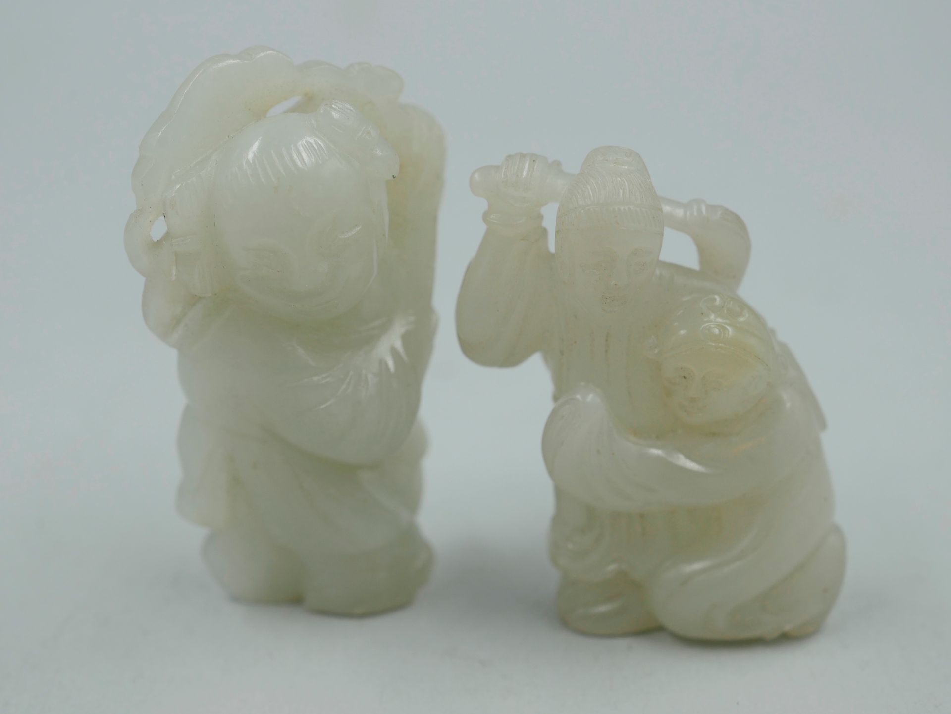 Null Two carved jade netsuke representing children playing. Height 4 and 5cm.