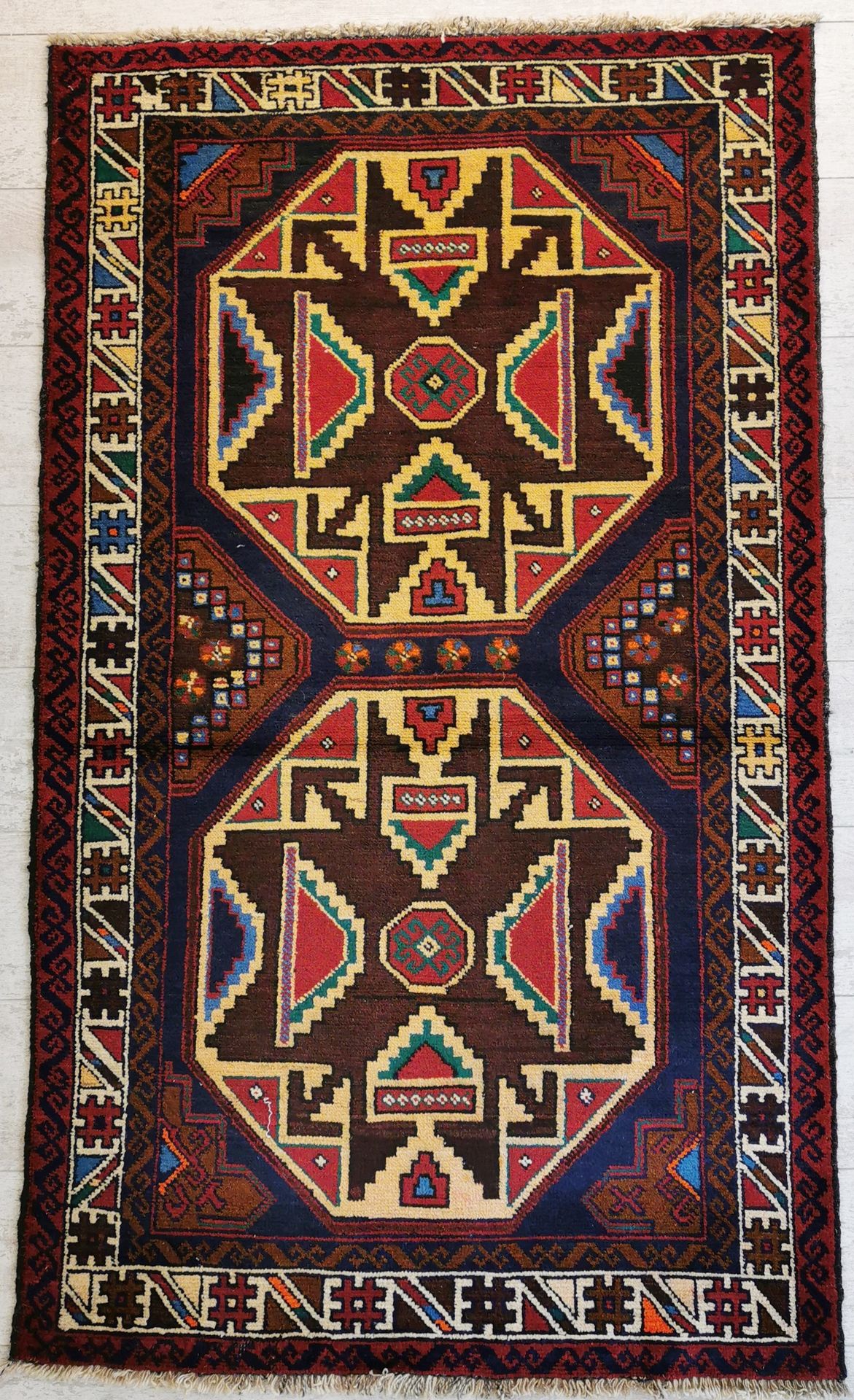 Null 伊朗。棕色背景上装饰有两幅对开的奖章的羊毛地毯，上面有几何图案。89 x 143厘米。