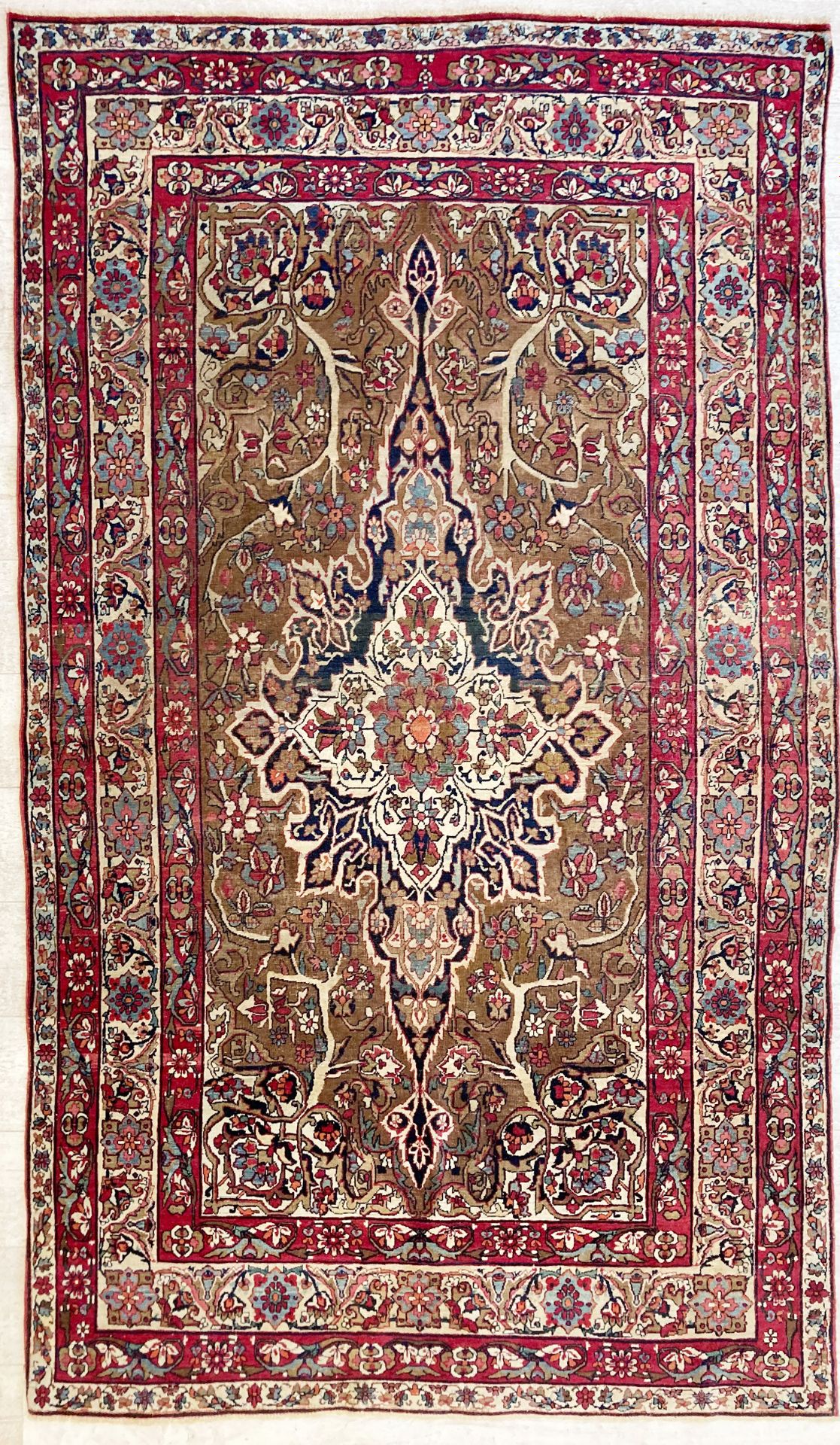 Null 一块波斯羊毛地毯，中央饰有花朵的徽章和四条横幅，在奶油色和棕色的背景上出现了植物图案，135 x 230厘米。(穿着)