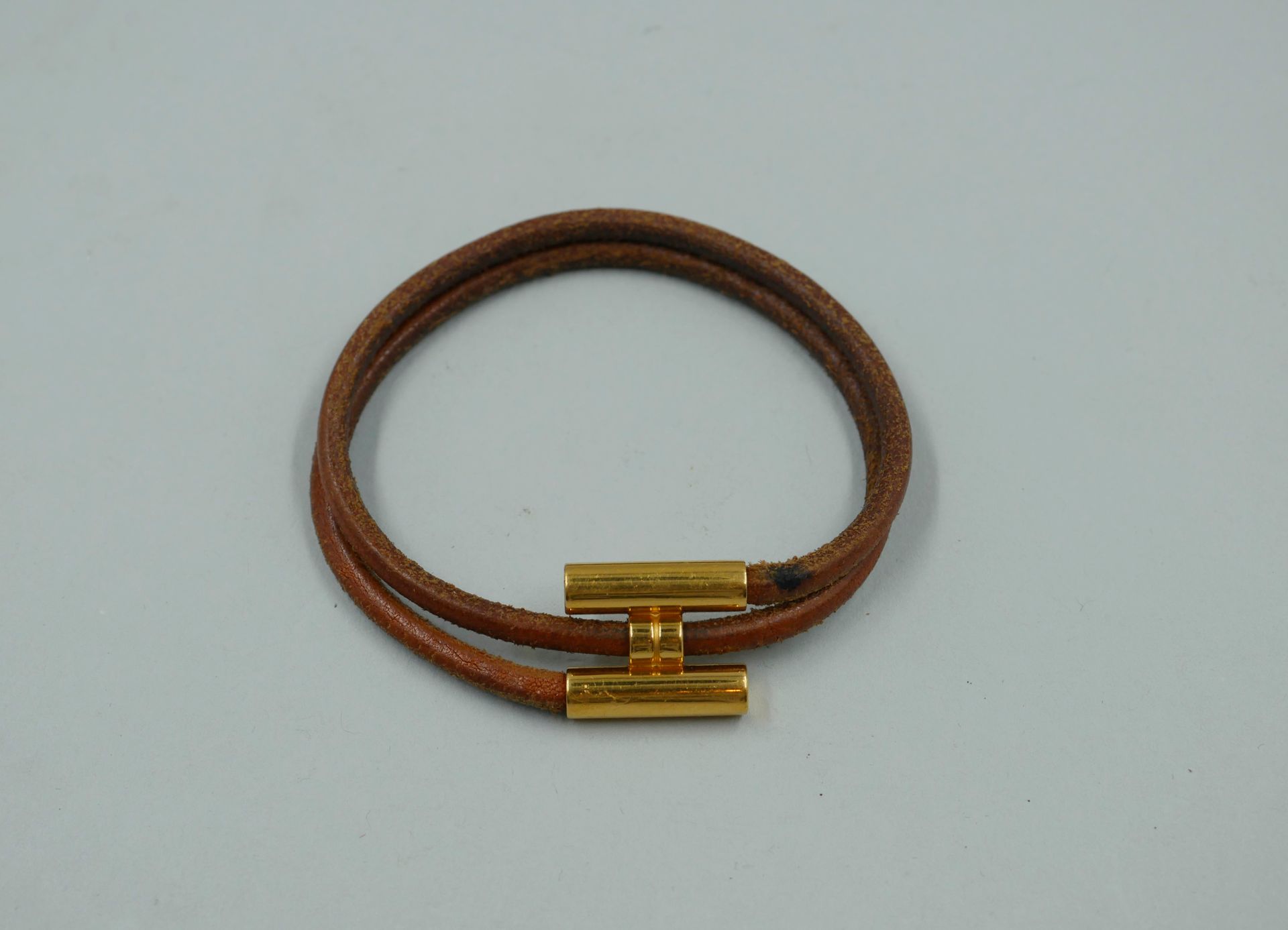 Null HERMES Paris. Bracelet "Tournis" en cuir naturel et métal doré. Signé. Etat&hellip;