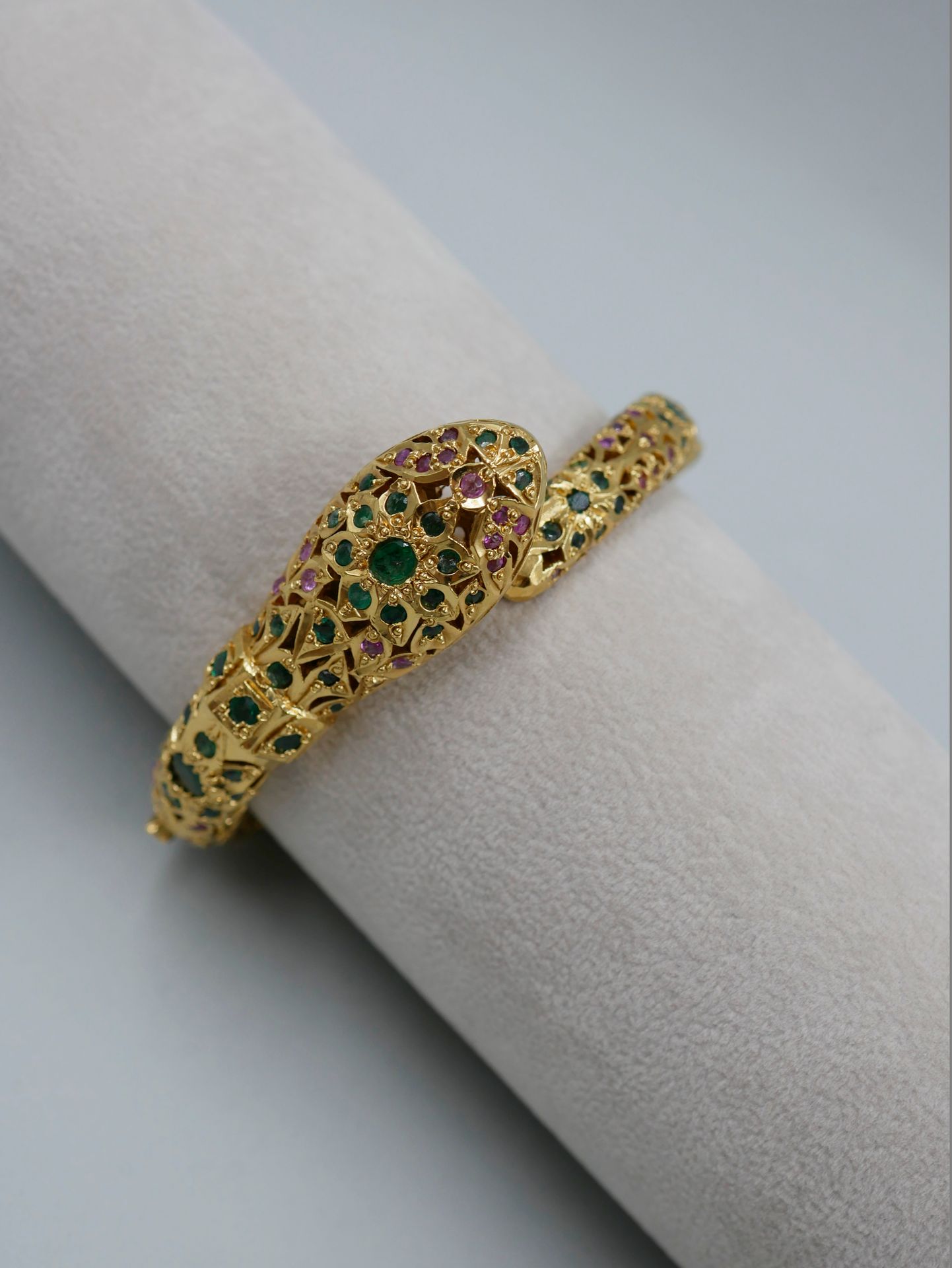 Null Bracelet jonc en métal doré ajouré figurant un serpent, serti d'émeraudes e&hellip;