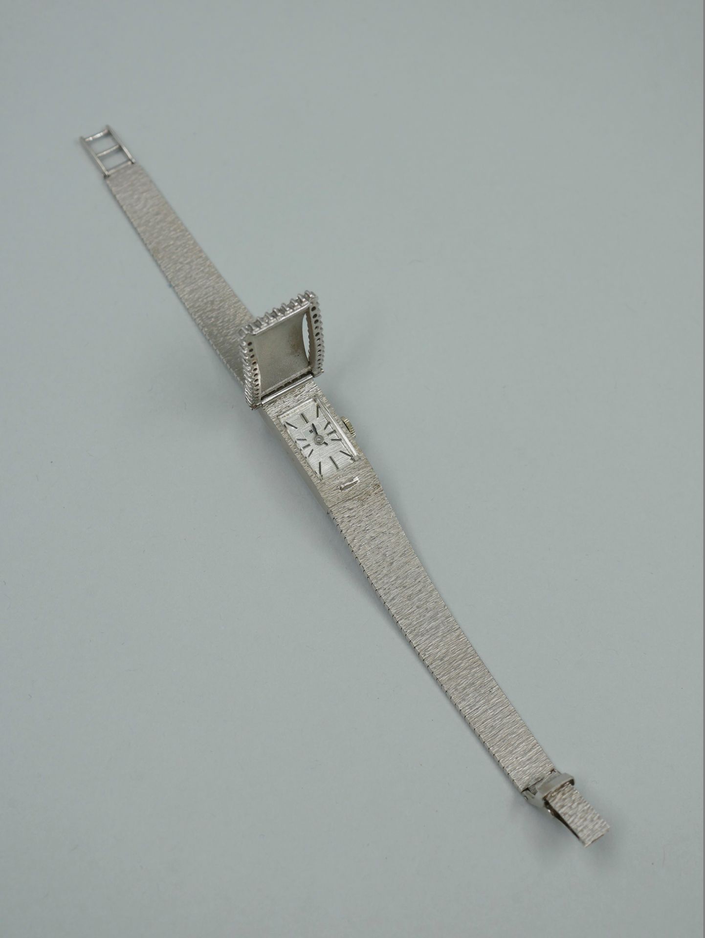 Null Montre bracelet de dame en or blanc 18k figurant une ceinture, le motif bou&hellip;
