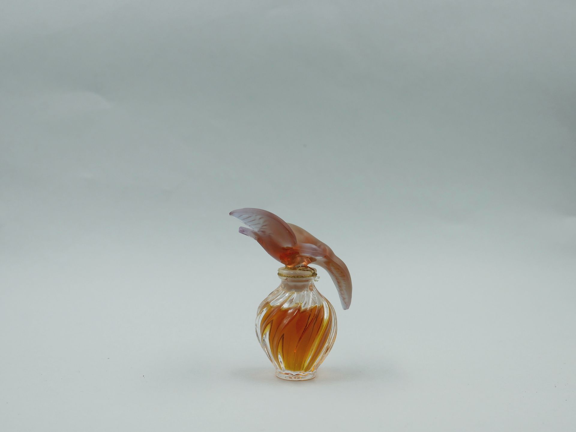 Null Nina Ricci和LALIQUE为L'Air du Temps（1948年）设计。

扭曲的瓮形瓶，塞子上有两只红色水晶的鸽子。

高度：9厘米。