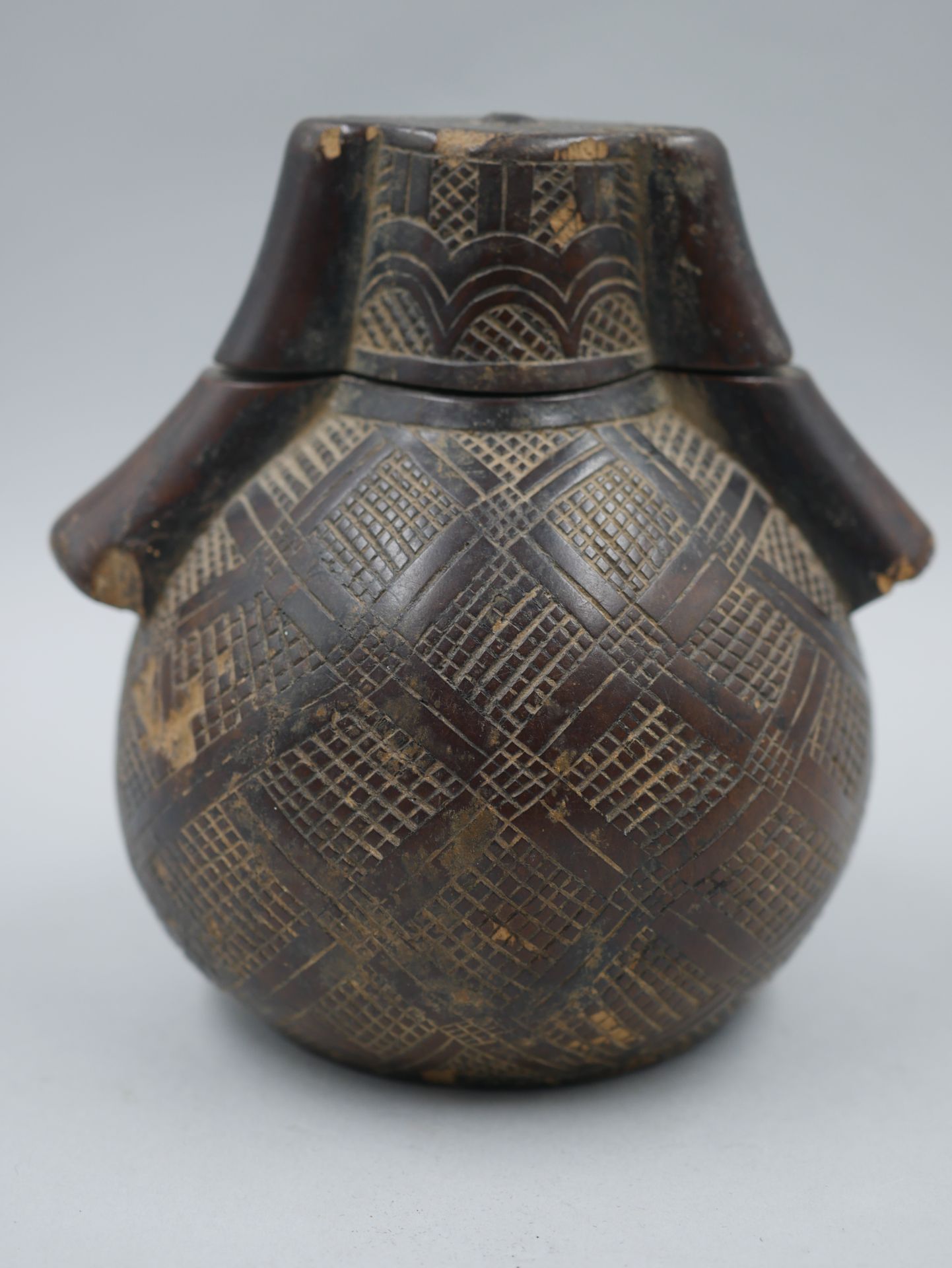 Null 冈比亚民主共和国。古典形状的木制火药瓶，装饰有烟熏制的几何图案。有深色的光泽。高度：11厘米。(事故）。)

出处：法国私人收藏。

从布鲁塞尔P. &hellip;