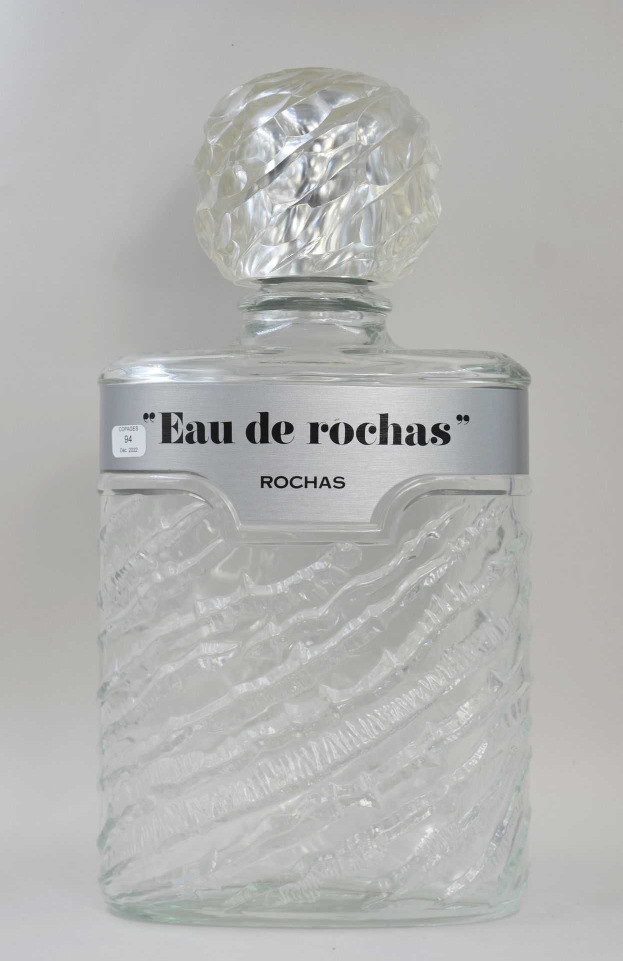 Null ROCHAS "L'eau de Rochas"（罗卡斯之水）。

玻璃装饰的假瓶，两面都有标题。

高：33厘米