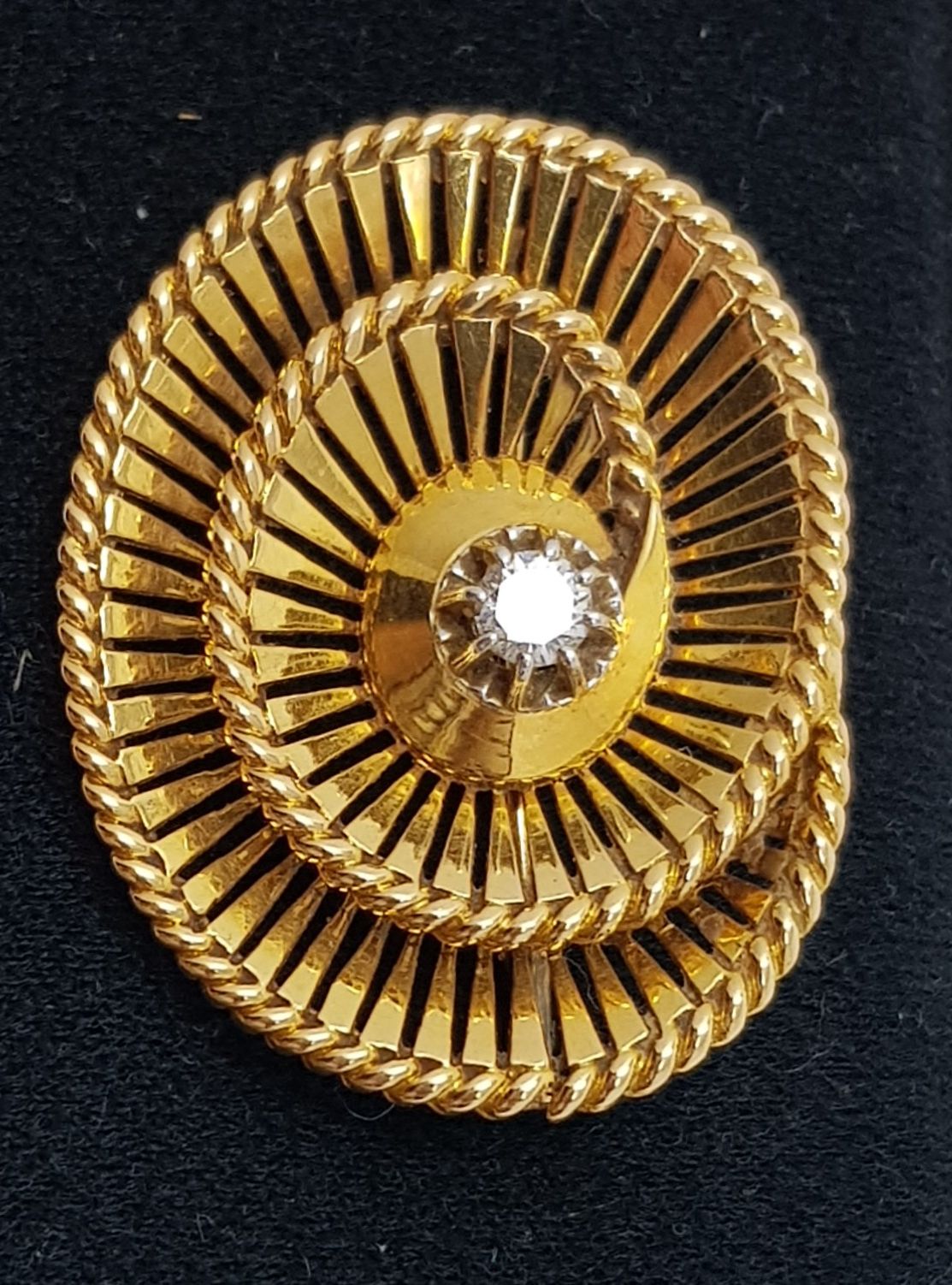 Broche spirale ajourée En or avec au centre un diamant 
Mit 0,25 Karat besetzt. &hellip;
