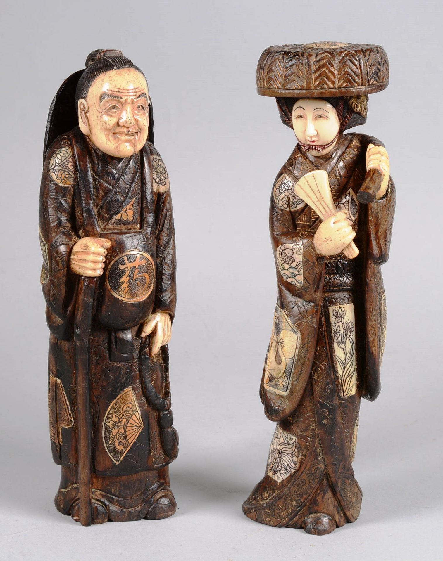 JAPON. 日本。

两个被称为菊花象的木雕人物，脸、手和衣服的一些细节都是用象牙雕刻的。女人，优雅，穿着和服，戴着帽子，拿着扇子，男人，可能是一个神道教的牧&hellip;