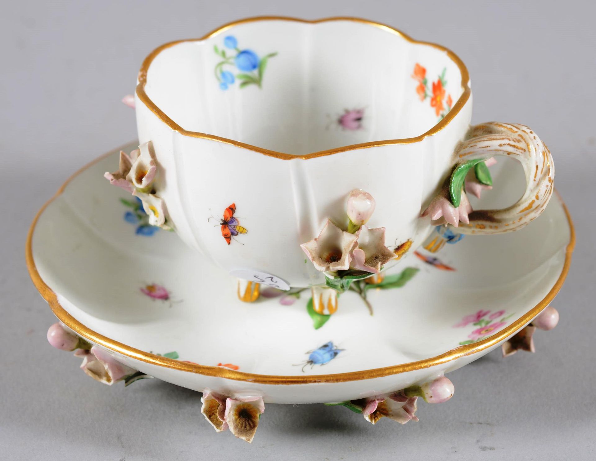 Petite tasse et soutasse.MEISSEN. 迈森。

小瓷杯和碟子，有应用的花卉装饰。

德国，19世纪末。有小块缺失。

尺寸：7厘米&hellip;