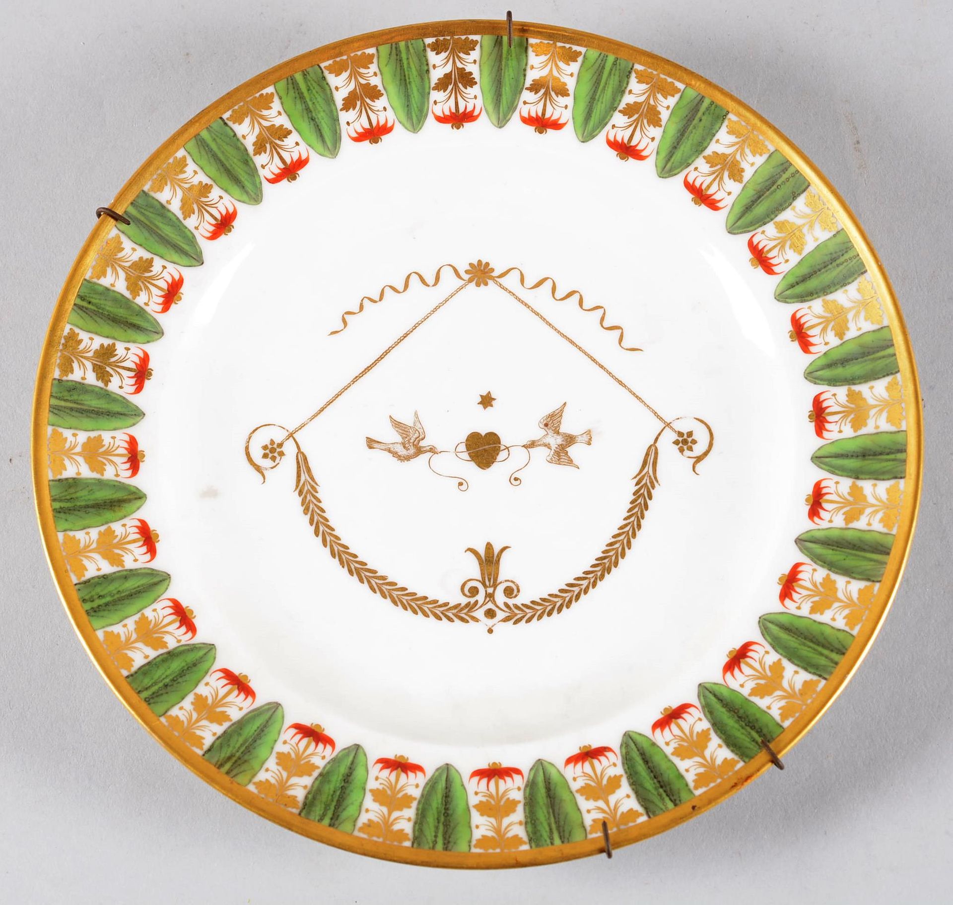 PARIS.Assiette en porcelaine 巴黎。

瓷盘上装饰着两只鸽子和一个由路易十六时期的绳结拉伸的弓。约1820年。

直径：23.5厘米
