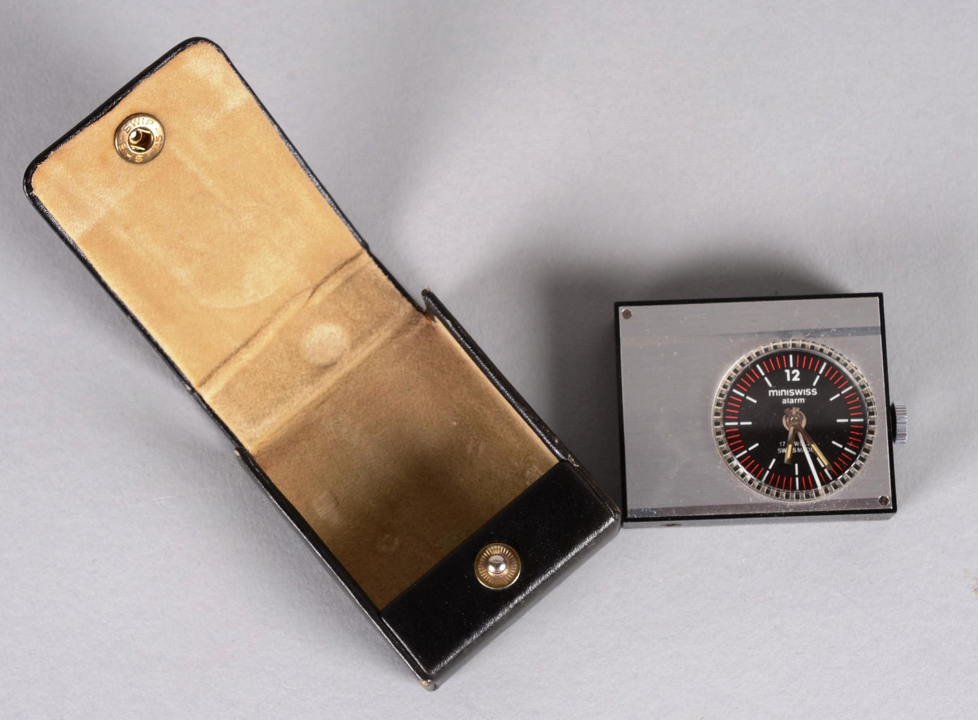 Réveil Miniswiss 古董MINISWISS闹钟旅行闹钟，17颗宝石，瑞士制造，带皮套，电池驱动，未检查。

总尺寸：5,50 x 4,50厘米