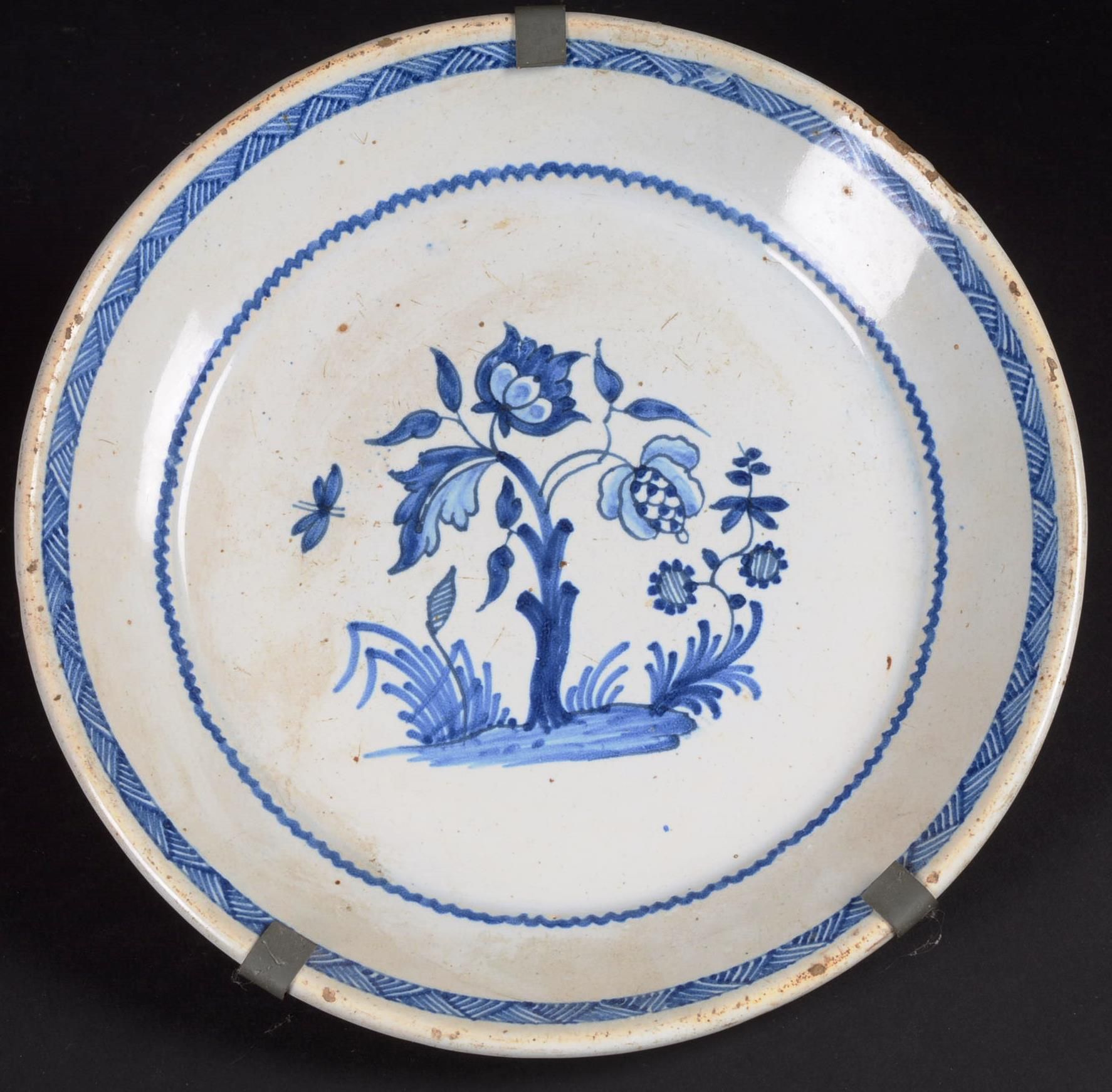 CENTRE : Assiette en faïence décorée NIVERNAIS。

陶器圆盘，用蓝色装饰着土丘上的花枝。

17世纪。

直径：2&hellip;