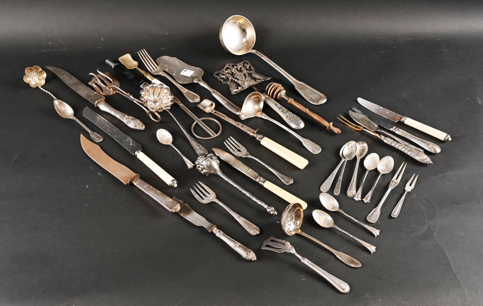 Fond de tiroir Bottom of drawer composed of silver plated serving utensils.

Kni&hellip;
