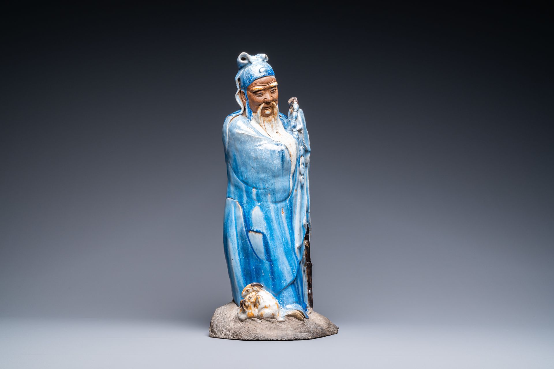 A large Chinese blue-glazed Shiwan pottery 'immortal' figure, 19th C. Vollständi&hellip;