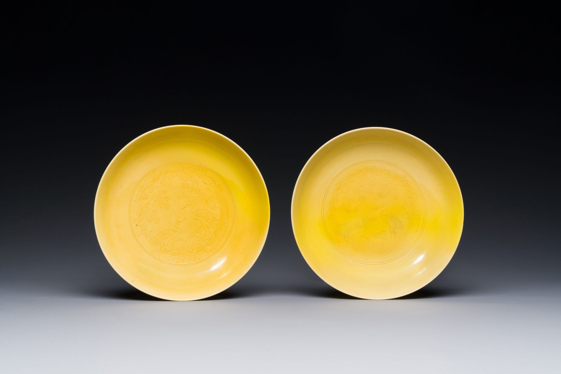 A pair of Chinese monochrome yellow-glazed saucers with incised designs of pine &hellip;