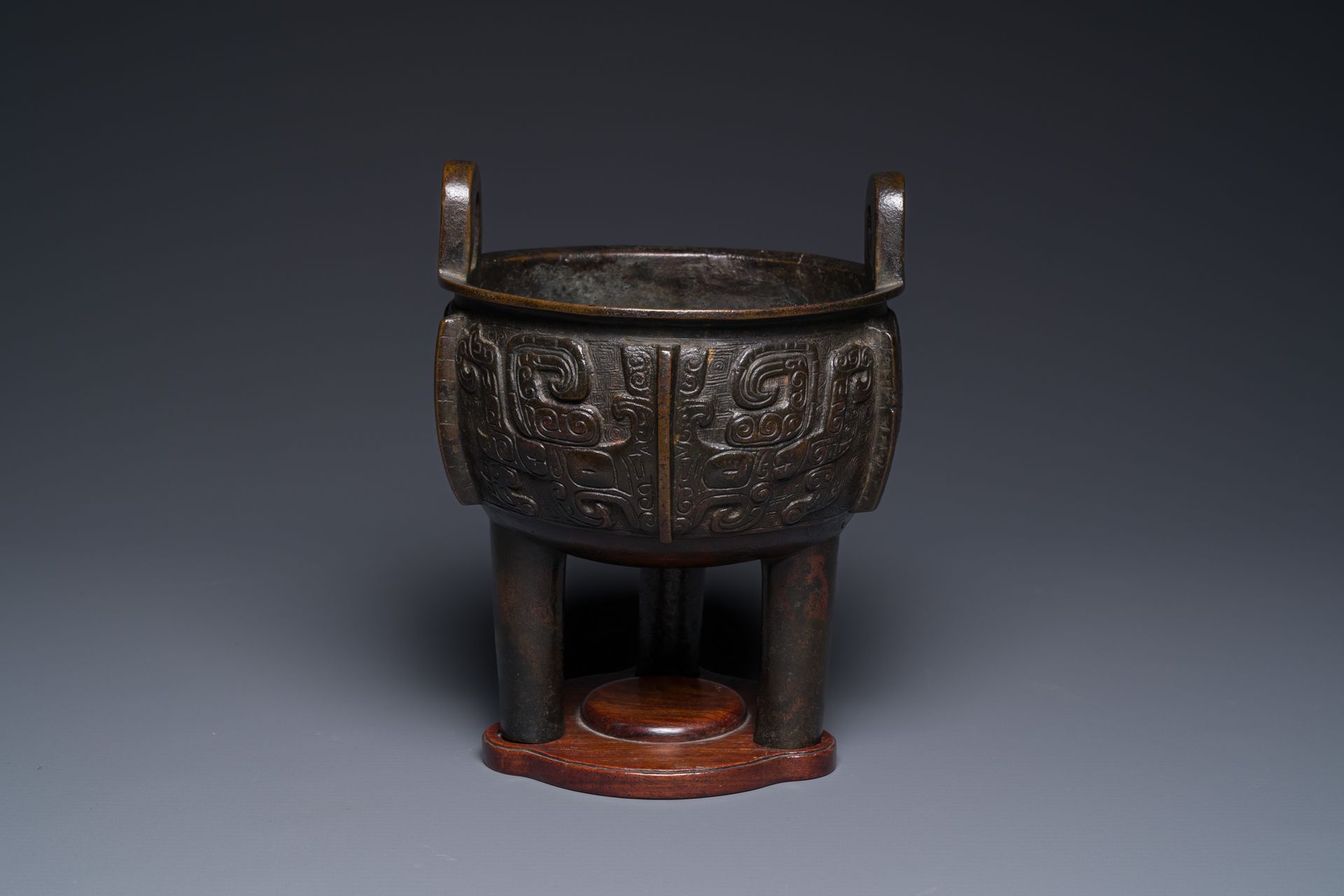 A Chinese archaistic bronze tripod censer on wooden stand, 'ding', Song/Ming Enc&hellip;
