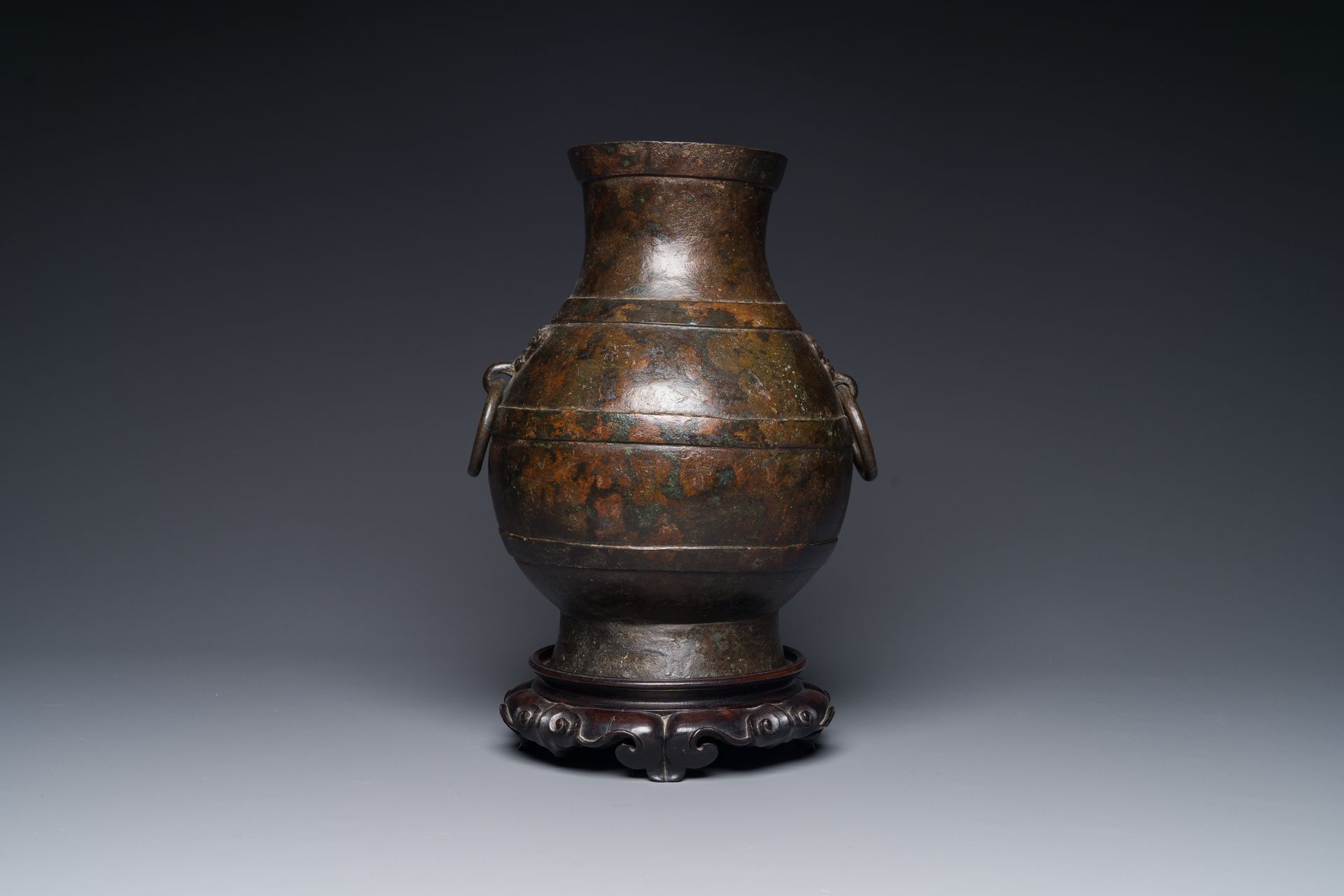 A Chinese bronze 'hu' vase with Han-style taotie handles on wooden base, Ming Va&hellip;