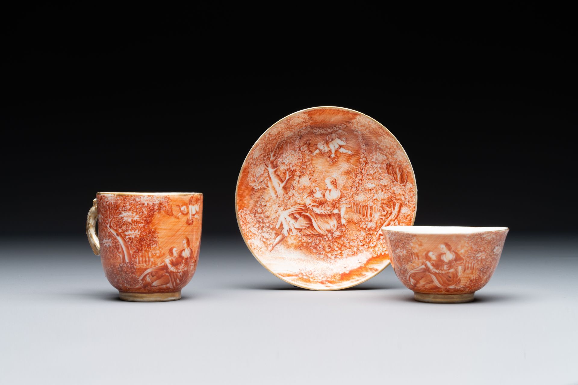 Two rare Chinese iron-red-decorated 'European scene' cups and a saucer, Qianlong&hellip;