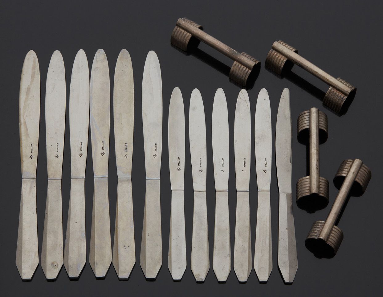 LOUIS VUITTON 一套19把大刀和14把小刀的钢制刀。
刀片上标有LV的字样。
，包括4个刀架。