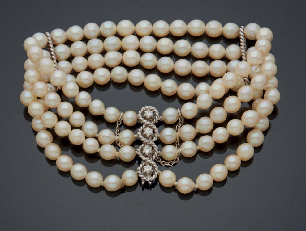 Null 由四排养殖珍珠组成的手链，零星地穿插在扭曲的白金线桥上。
，滑动棘轮扣，镶嵌明亮式切割钻石，安全链。法国60年代的作品。
毛重：32.4克。