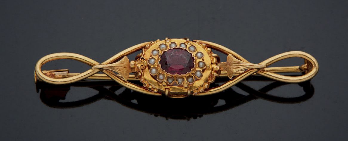 Null Yellow gold brooch 750 mm set in the center with a garnet in a circle of sm&hellip;