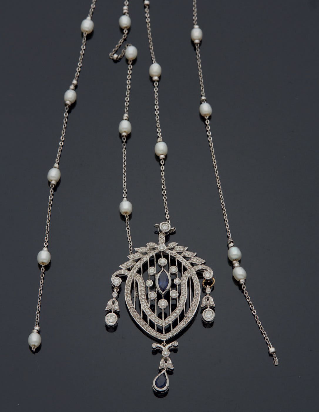 Null 
镂空印度水果金质吊坠，以一颗小型梯形切割蓝宝石为中心，周围是密镶切割钻石。古代作品的味道中的现代作品。



毛重：17.8克。