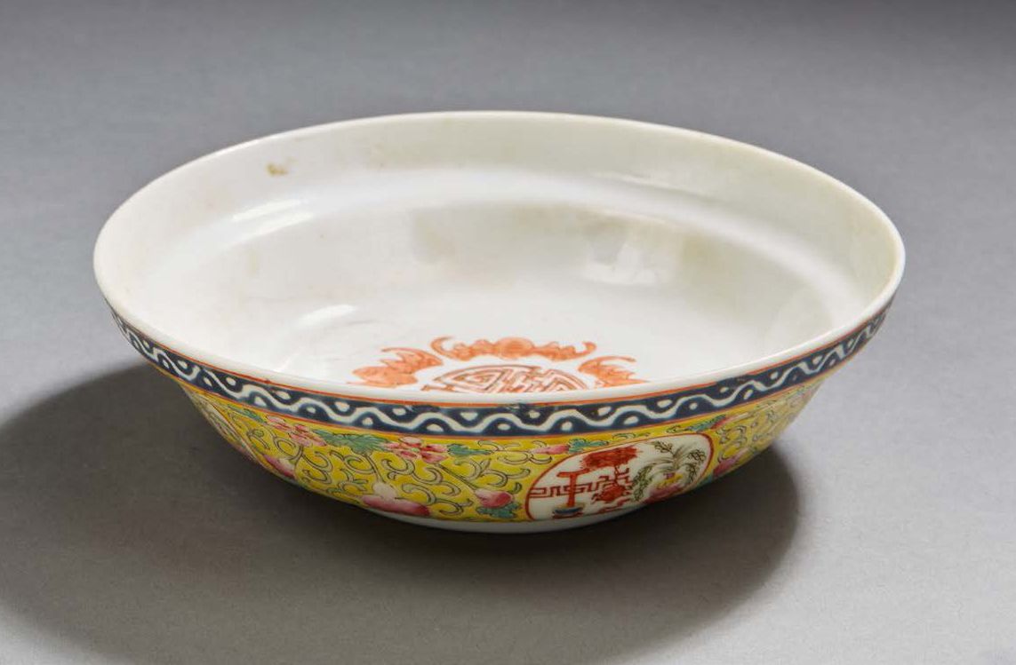 CHINE Circular porcelain bowl with yellow background decorated in Famille Rose e&hellip;