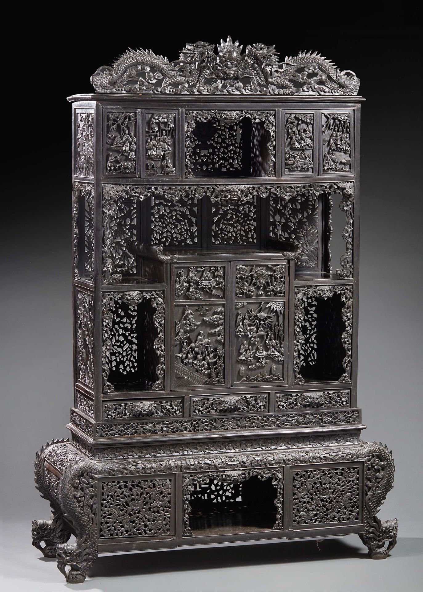 CHINE A richly carved and openworked fruitwood cabinet. The whole is decorated w&hellip;