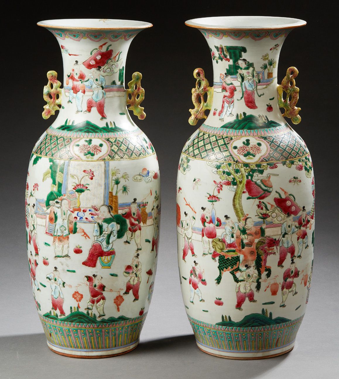 CHINE 一对大的瓷器柱形花瓶，用多色珐琅彩装饰着儿童和年轻妇女在花园里玩耍，肩部装饰着十字架，手柄为卷轴形式
广州 - 约1900年
高：58厘米