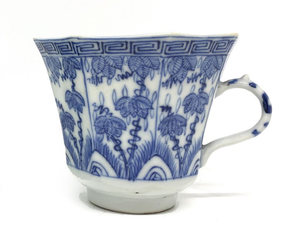 CHINE 八角形单柄瓷杯，釉下青花装饰造型叶子。
背面有康熙款，双圈内有四个青花字。
康熙年间1662-1722
高6.5厘米。