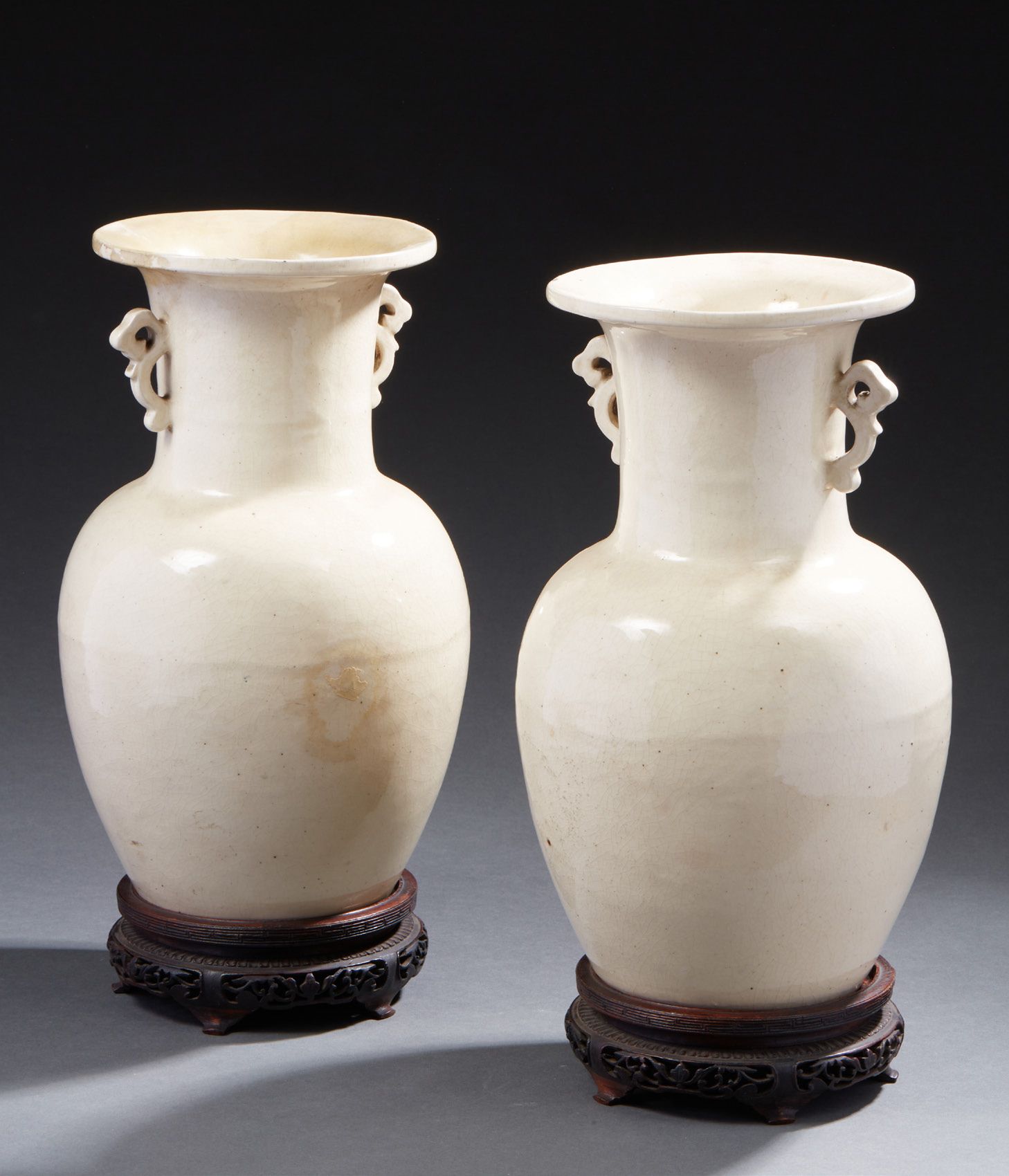CHINE 一对炻器柱形花瓶，有两个镂空把手，施奶油釉，略有裂纹
19世纪
其中一个花瓶的颈部曾被修复过
高：31厘米
附有中印公司艺术馆1930年的文件。这张&hellip;