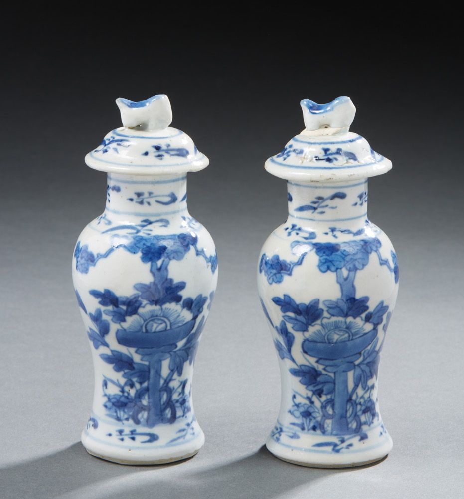 CHINE A pair of small covered porcelain vases decorated in blue with flowers. On&hellip;