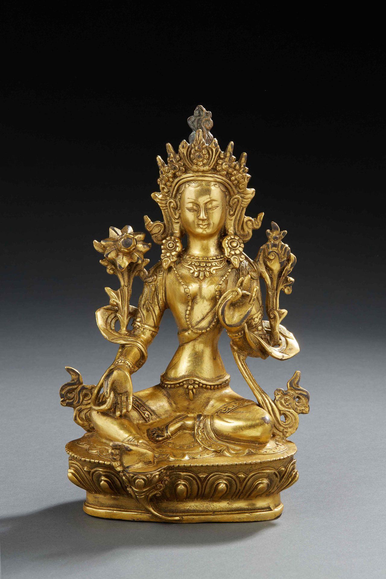 Null 西诺-提贝坦艺术（或喜马拉雅） - 鎏金铜质特拉女神像，周围环绕着鲜花和缎带，头戴头饰，头顶火焰，坐在莲花形底座上。


20世纪。


H.20厘米
