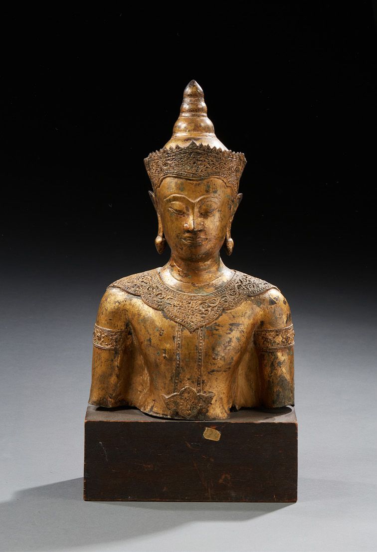 THAÏLANDE Busto di Buddha in bronzo dorato.
Base rettangolare in legno.
H.: 42 c&hellip;